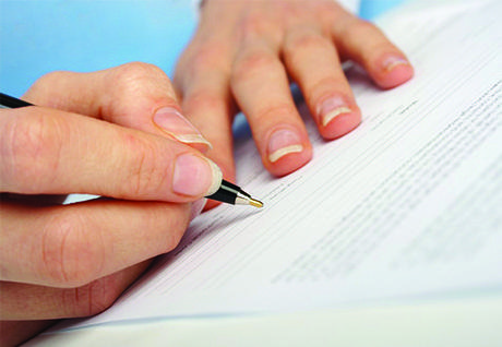 two hands, right hand writing on paper