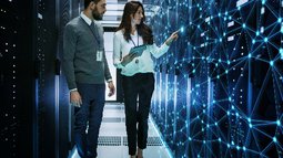 Female and Male IT Engineers Discussing Technical Details in a Working Data Center_ Server Room with Internet Connection Visualisation.jpg