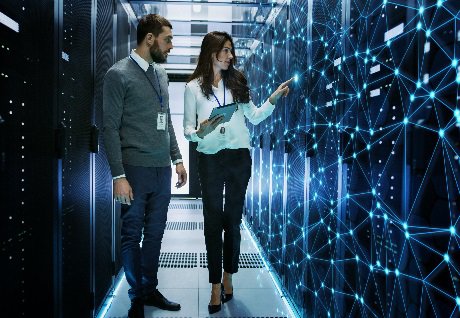 Female and Male IT Engineers Discussing Technical Details in a Working Data Center_ Server Room with Internet Connection Visualisation.jpg